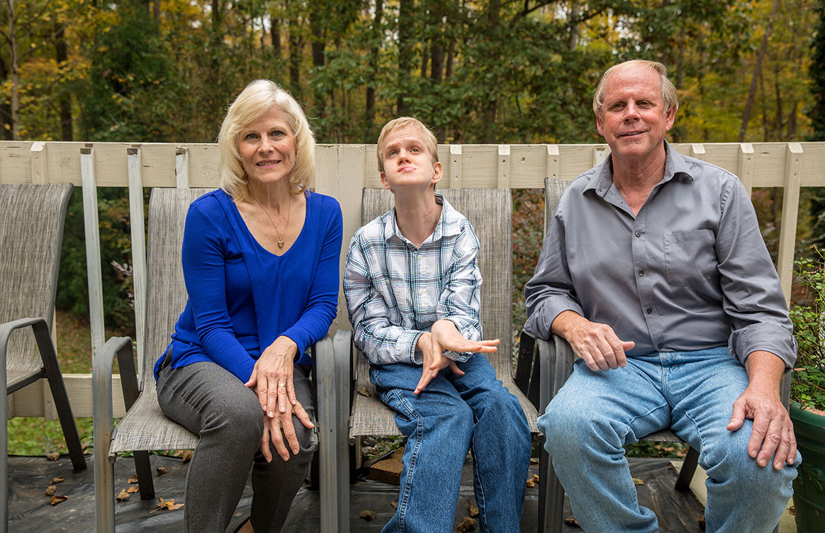 A boy and his parents seated outside
